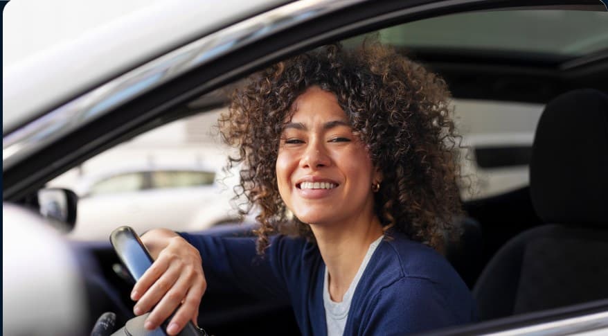 Mulher ao volante do carro recém-conquistado